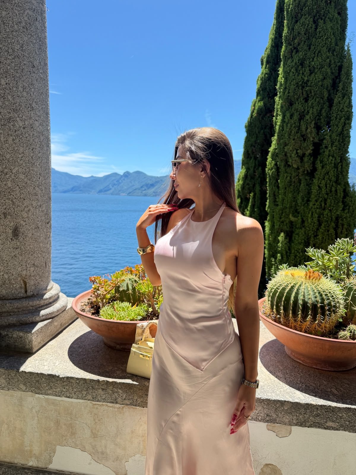 Liliia Shchepkiv in a pale pink dress by Lake Como